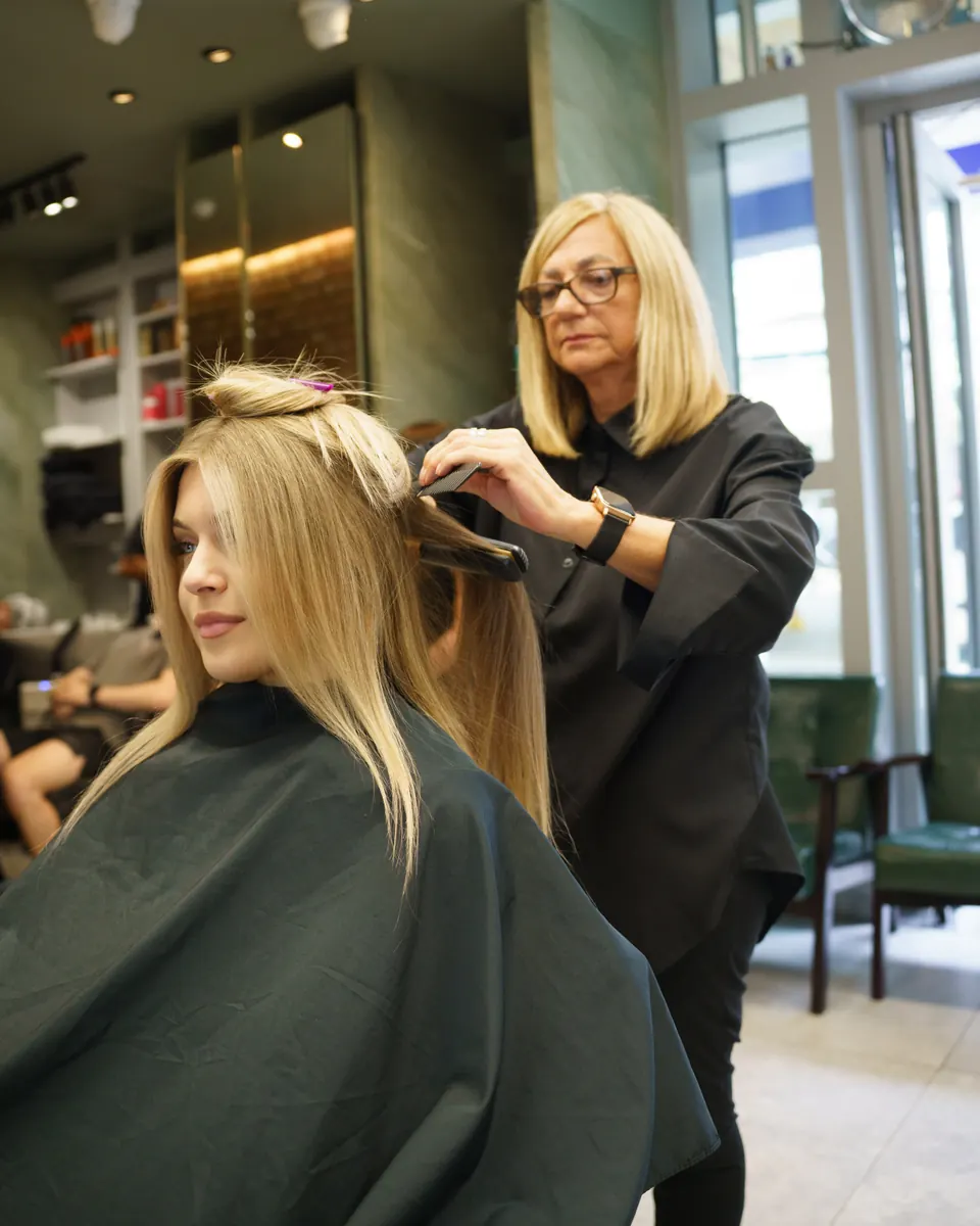 Lorraine sectioning a client’s blonde hair