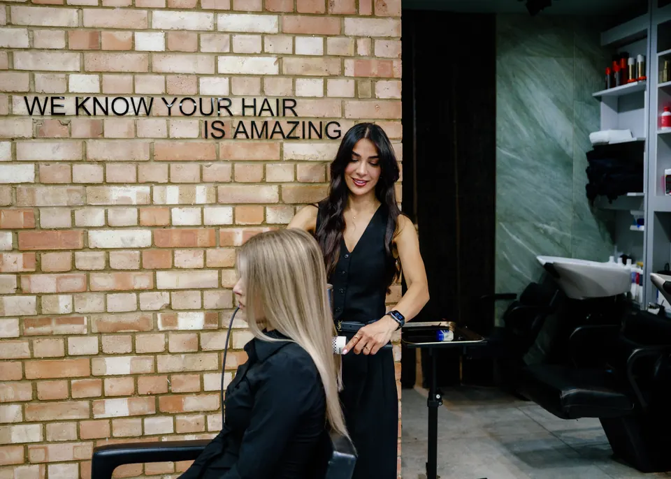 Fatima with a client by the brick wall