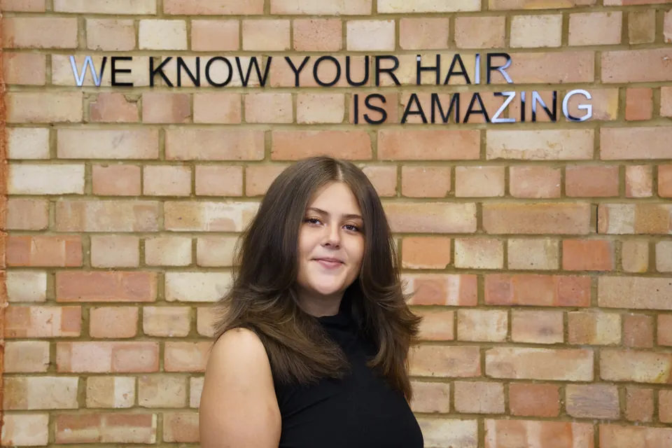 Long brown hair against the brick wall